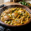 Moroccan chicken tagine with preserved lemon and olives simmering with golden saffron sauce