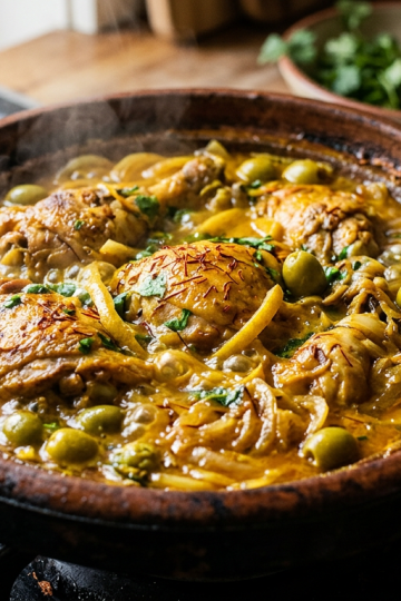Moroccan chicken tagine with preserved lemon and olives simmering with golden saffron sauce