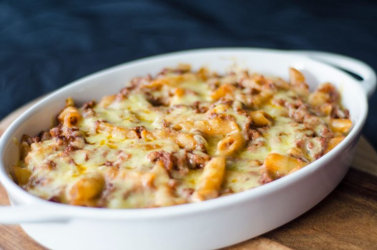 Baked stuffed and layered meatballs in a casserole dish with melted cheese and tomato sauce