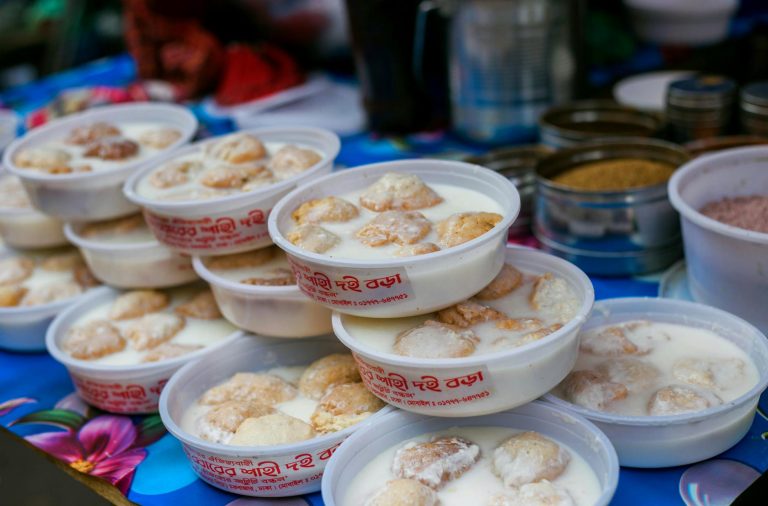 small white bowls of silky ginger milk pudding topped with honey and sliced ginger
