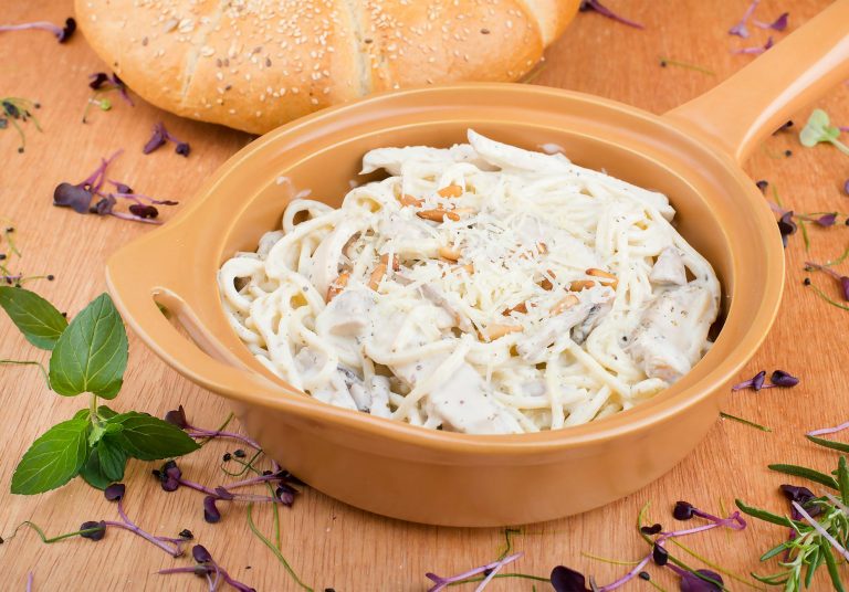 Skillet filled with creamy keto chicken alfredo with broccoli and zucchini noodles