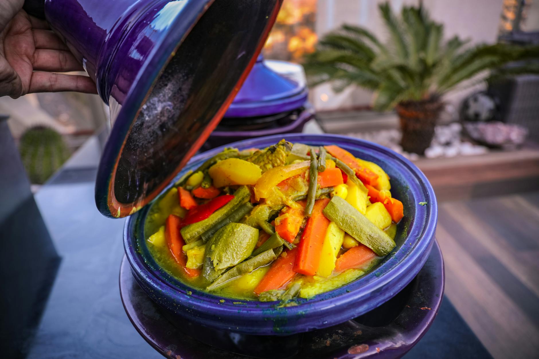 Overhead view of Moroccan chicken tajine with apricots, olives, and herbs in a traditional clay dish