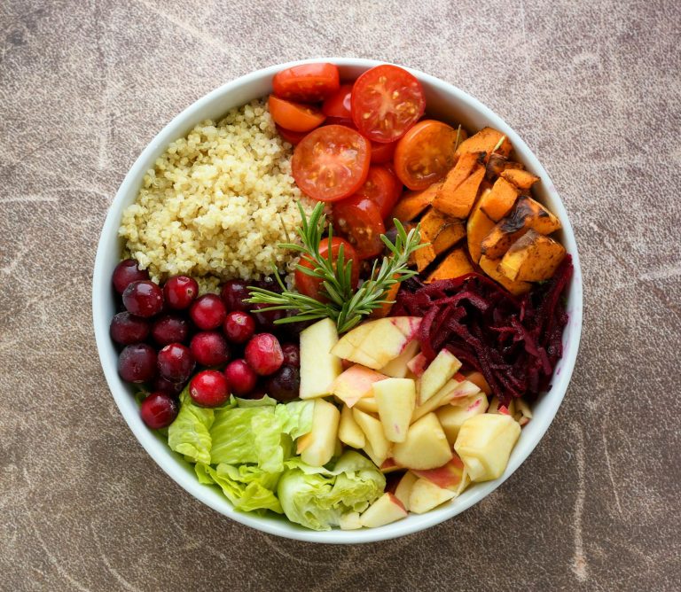Colorful healthy quinoa Buddha bowl with roasted vegetables and tahini dressing