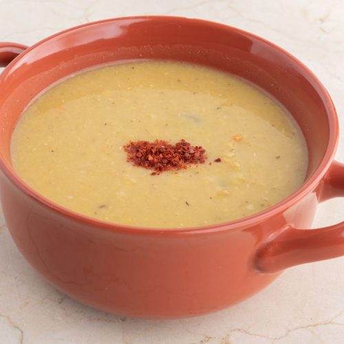 Creamy Turkish red lentil soup mercimek in a bowl with lemon and chili oil drizzle