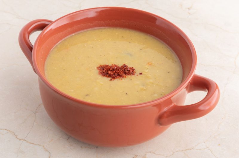 Creamy Turkish red lentil soup mercimek in a bowl with lemon and chili oil drizzle