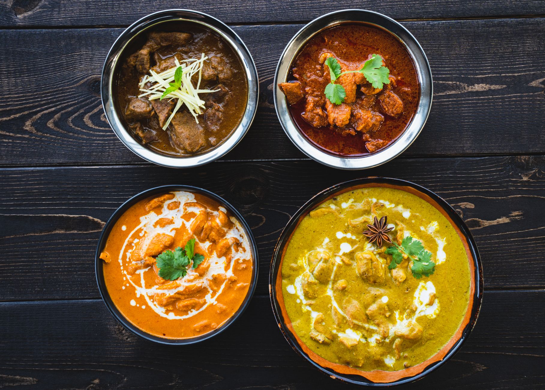 Bowl of Indian butter chicken masala with basmati rice and naan