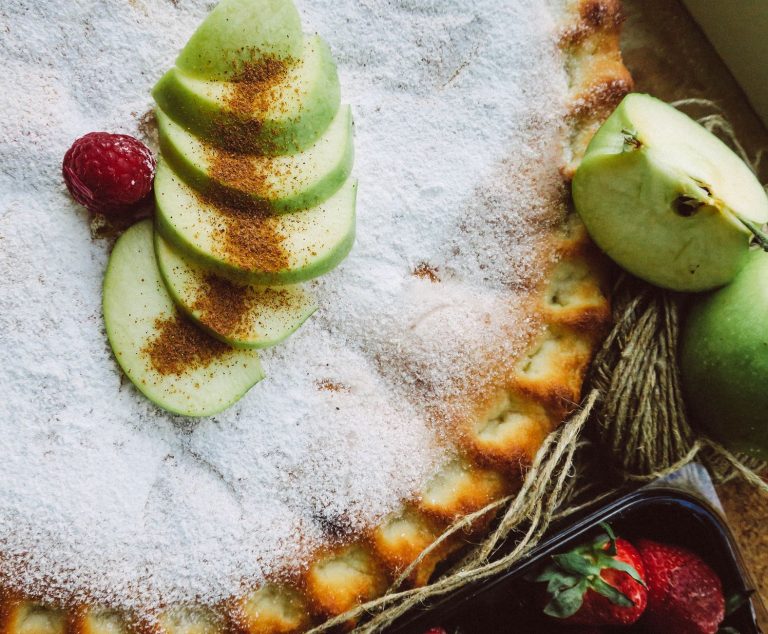 slice of classic apple pie with flaky lattice crust on a plate with vanilla ice cream