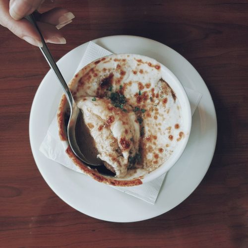 classic french onion soup in crocks with melted gruyere and baguette on top