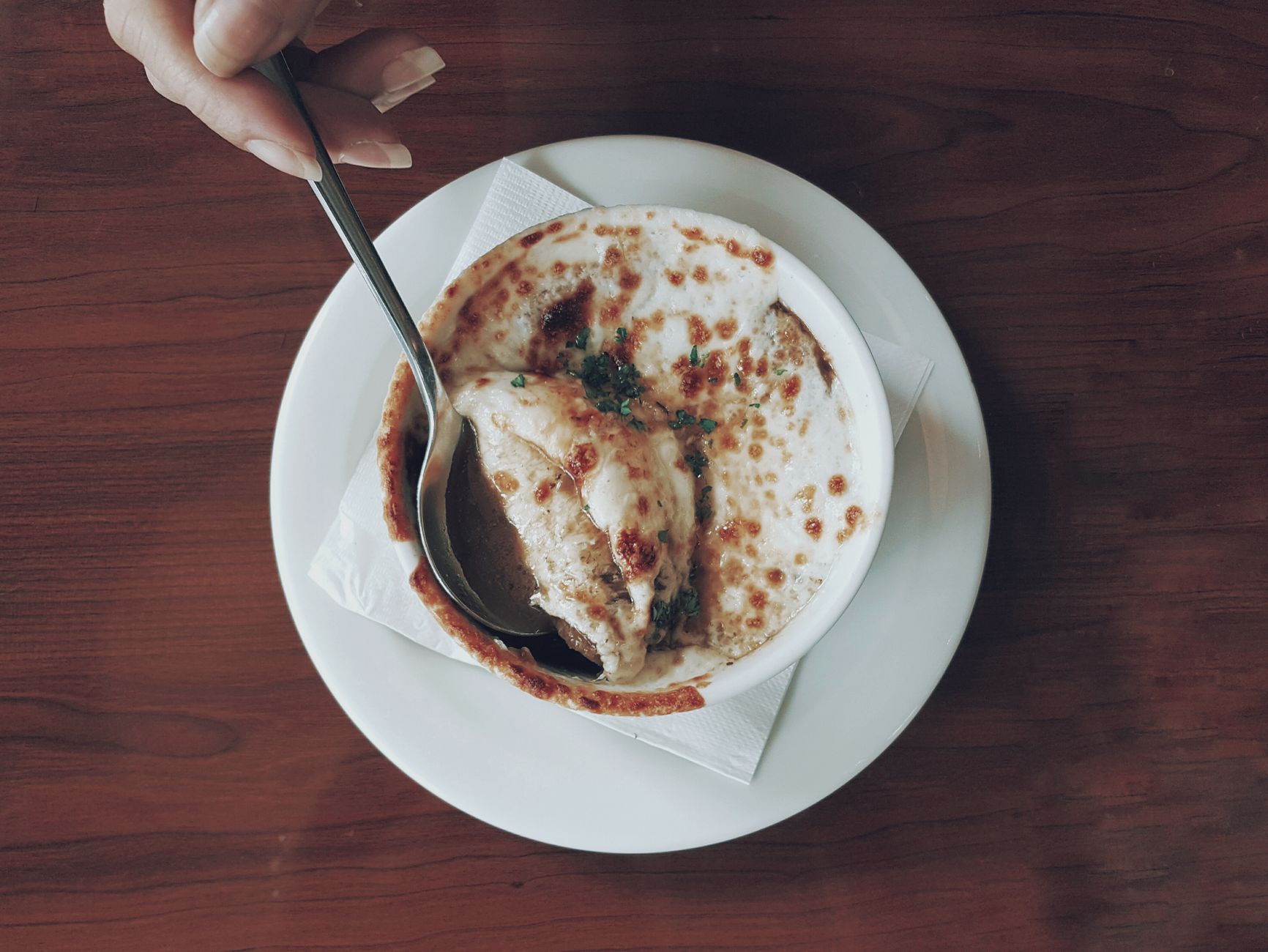 classic french onion soup in crocks with melted gruyere and baguette on top
