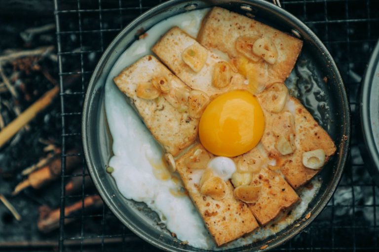 Crispy honey garlic tofu coated in glossy sauce with sesame seeds and green onions