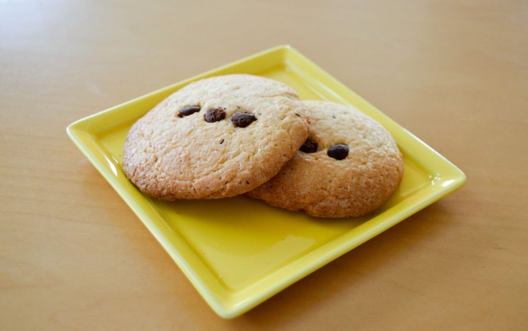 Stack of chewy gluten free chocolate chip cookies on a cooling rack