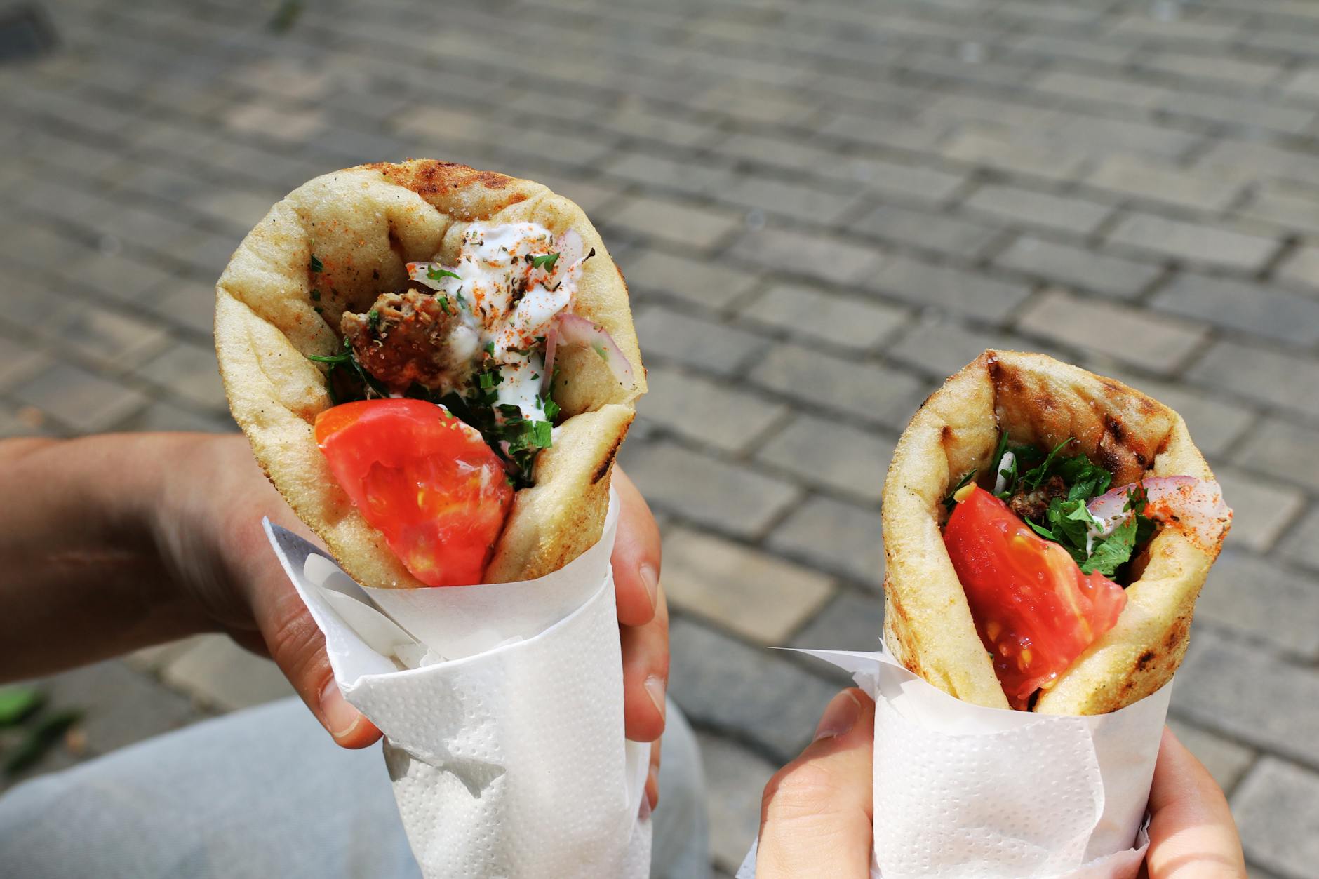 Grilled healthy Greek chicken souvlaki skewers with veggies, pita, and yogurt sauce on a platter