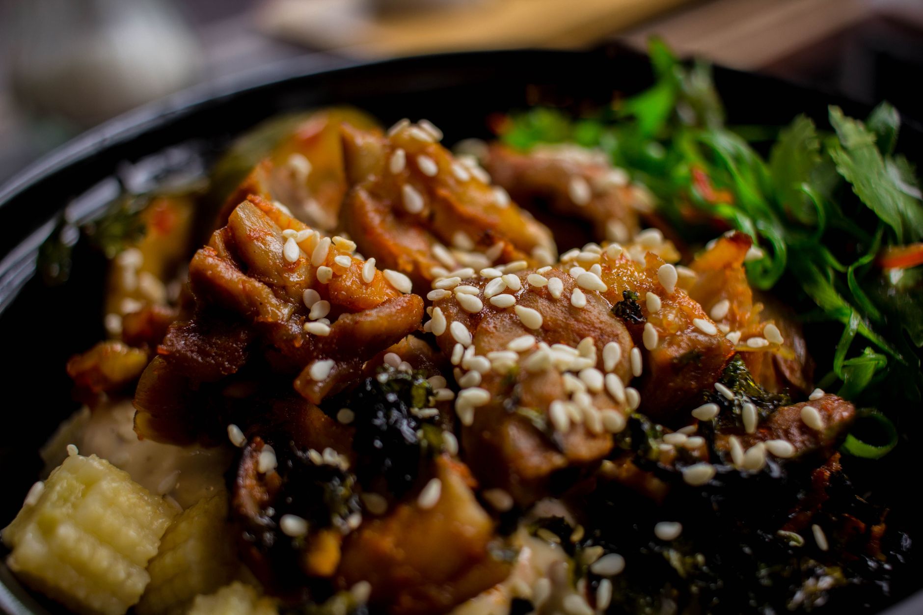 Chinese honey sesame chicken served over rice with sesame seeds and green onions