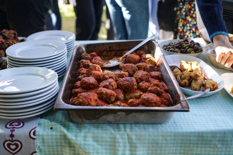 Baked Mediterranean lamb meatballs with tzatziki, pita, and fresh vegetables on a serving platter