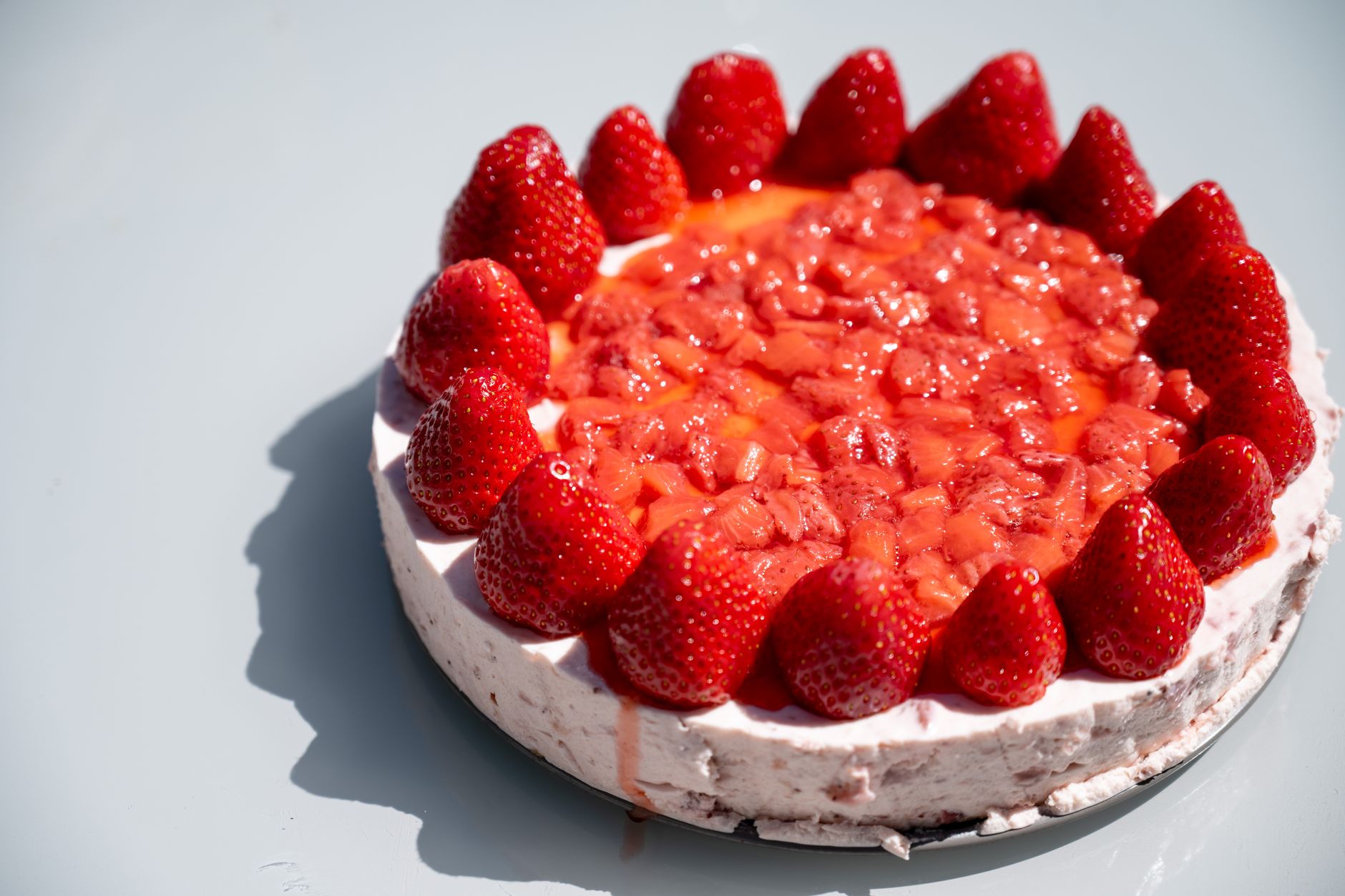 easy no bake strawberry cheesecake topped with fresh sliced strawberries on a graham cracker crust