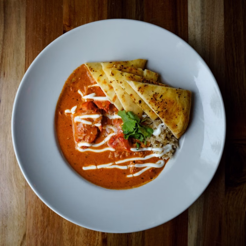Chicken tikka masala with basmati rice, naan and cilantro