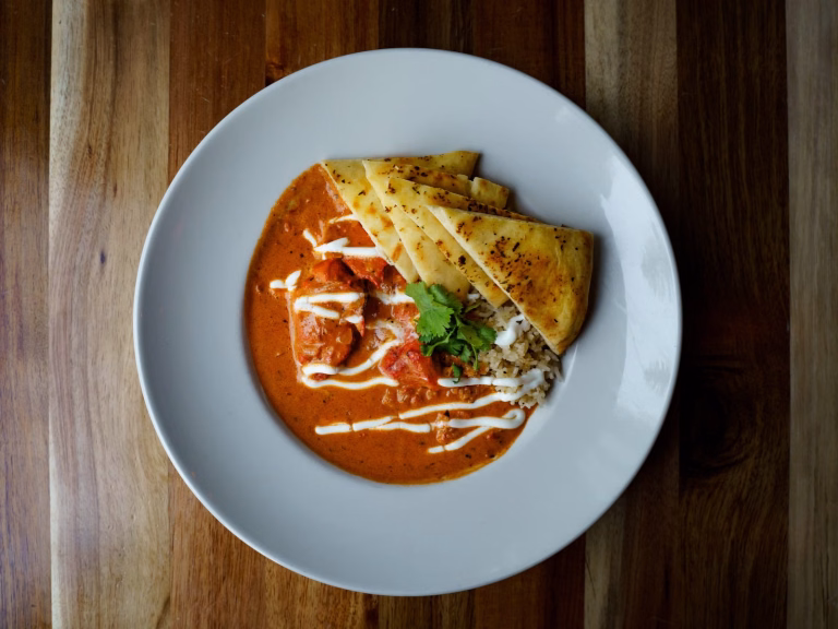 Chicken tikka masala with basmati rice, naan and cilantro