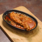 Chicken drumstick in a thick red sauce