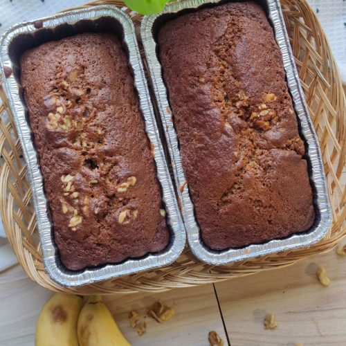 Easy vegan banana bread loaves made in one bowl, topped with chopped walnuts and sliced bananas